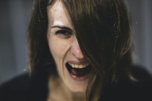 a picture of a woman screaming to depict the intensity of shouting to avoid looking at a substance use problem